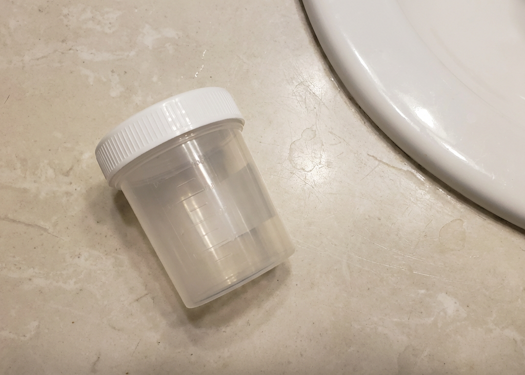 Clear plastic container with a white lid on a beige surface